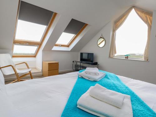 a bedroom with a bed with two towels on it at Still Waters in Wyke Regis