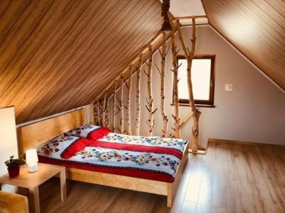 a bedroom with a bed with a wooden ceiling at Domki Eden z Ballią in Gołubie