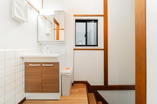 a small bathroom with a sink and a window at NISHIKI Ryokan錦旅館 in Tokyo
