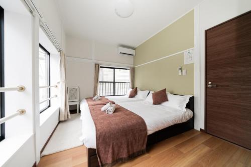 a bedroom with a bed with a stuffed animal on it at NISHIKI Ryokan錦旅館 in Tokyo