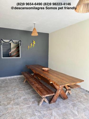 a wooden table with a bench in a room at Descanso Milagres in São Miguel dos Milagres