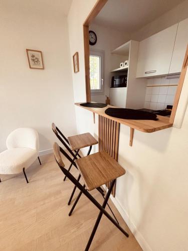 Charming new studio في لا روشيل: مطبخ مزود بمنضدة وكراسي في غرفة
