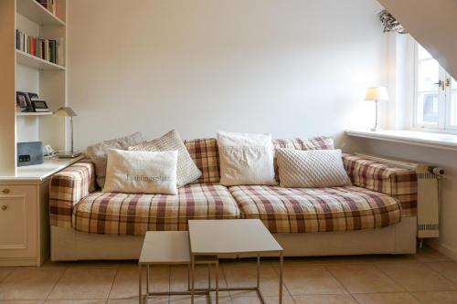 a living room with a couch with pillows at Westerhoern 46 Haus 2 App 24 in Keitum