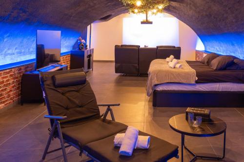 a room with two beds and a chair and a table at L'escapade Vosgienne, Cinéma, Balnéo in Remiremont