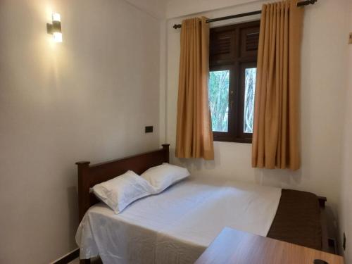 a small bedroom with a bed with a window at Calm Stay in Badulla