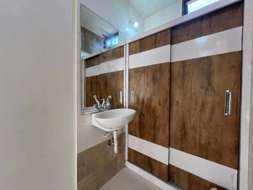 a bathroom with a sink and a wooden wall at Green Paradise - Trimbakeshwar in Trimbak