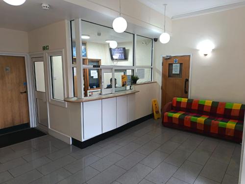 a waiting room with a couch and a television at Ilford York Hotel in Ilford