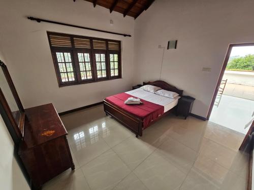 a bedroom with a bed with a red blanket at Queens Residence Homestay in Kandy