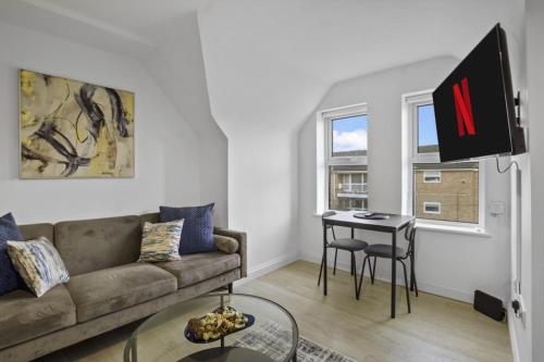a living room with a couch and a table at Modern Apartment I Self Check-in I Wi-Fi I Free Private Parking I Sleeps 3 in Bedford