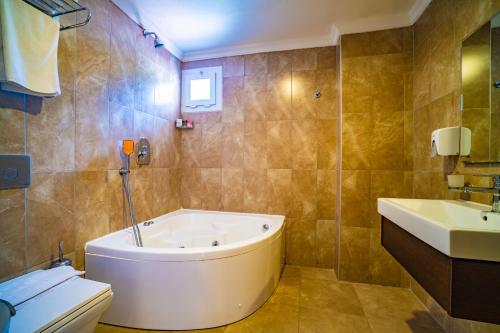 ein Badezimmer mit Badewanne, Toilette und Waschbecken in der Unterkunft Sunshine Holiday Resort in Oludeniz