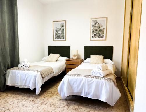 two beds sitting next to each other in a room at El Retiro de Albarreal - Chalet 3 hab, Aire Acondicionado y Entrada Piscina Gratuita in Albarreal de Tajo