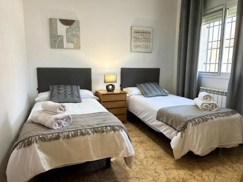 a bedroom with two beds with towels on them at El Retiro de Albarreal - Chalet 3 hab, Aire Acondicionado y Entrada Piscina Gratuita in Albarreal de Tajo