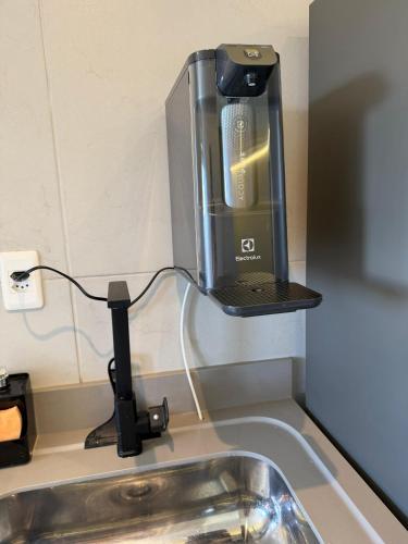 a kitchen sink with a laptop on top of it at Flat Red Sorocaba - Yellow in Sorocaba