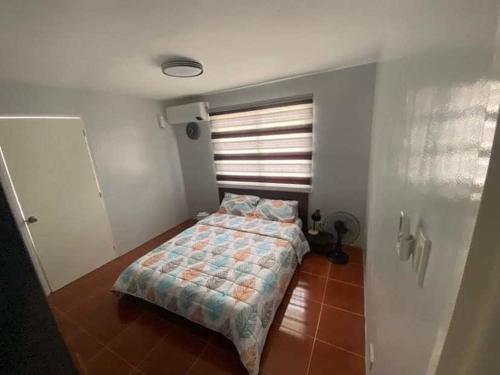 a bedroom with a bed in a room with a window at AD3M Haven's Place in Bantug