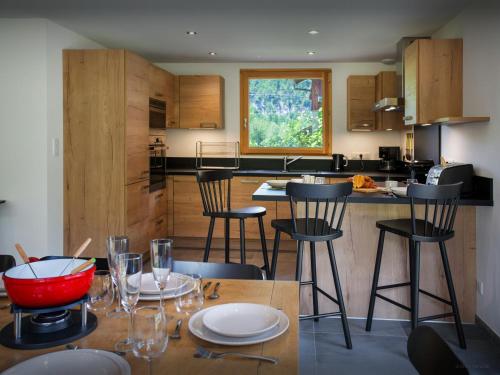 a kitchen with a table with chairs and a counter at Chalet Morris - OVO Network in Sixt