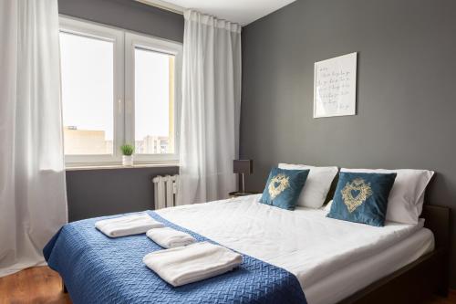 a bedroom with a large bed with towels on it at Reda Cozy Nest Apartment by BookingHost in Reda
