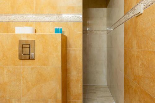 a shower in a bathroom with orange tile at Reda Cozy Nest Apartment by BookingHost in Reda
