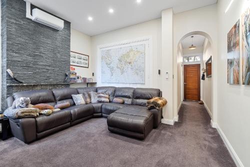 a living room with a brown leather couch at Huge, Inner Sydney City 5 Bed Mansion, Near Opera House - 7 mins in Sydney