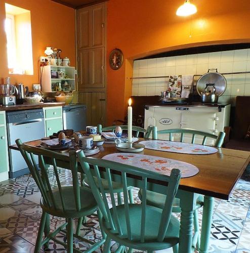 a kitchen with a table and chairs with a candle on it at Shannonview Country House in Labasheeda