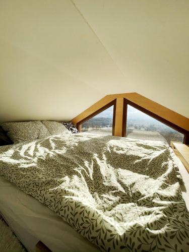a bed in a room with a large window at Glampeak Adamov in Adamov