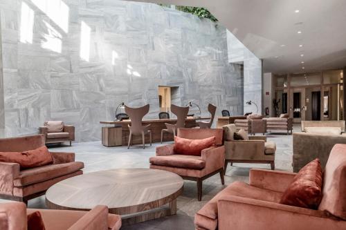 a lobby with couches and tables and a stone wall at NIDUM - Casual Luxury Hotel in Seefeld in Tirol