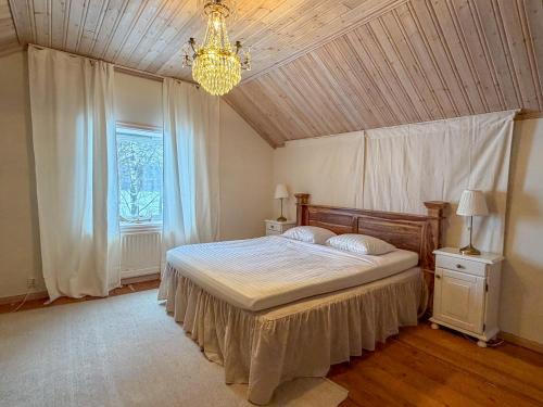 a bedroom with a bed and a chandelier at Secluded Lakehouse in Falun