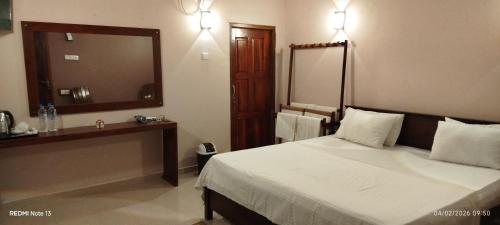 a bedroom with a bed and a large mirror at Voyager's Villa in Habarana