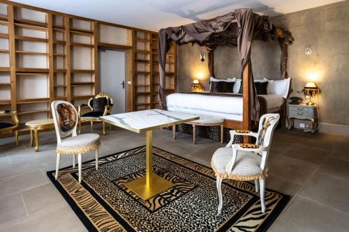 a bedroom with a bed and a table and chairs at Le Clos Violette et Le 11 D'Aglaé - Appart' Hôtel de Charme Design de Luxe in L'Isle-sur-la-Sorgue