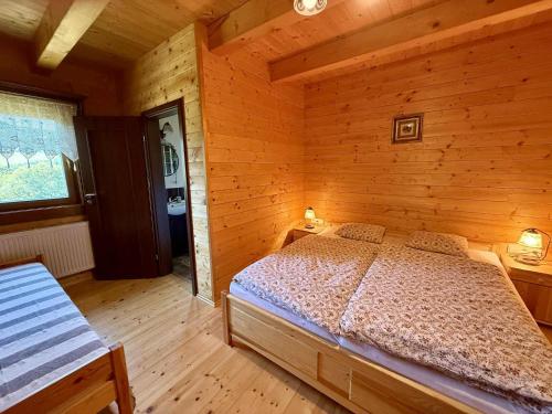 a bedroom with a bed in a wooden cabin at Chata RAIKA in Čierny Potok