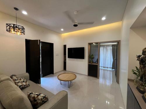 a living room with a couch and a table at Spacious Garden Home in Aurangabad