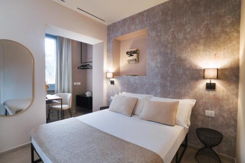 a bedroom with a large white bed and a mirror at Camillò Guest House in Ivrea