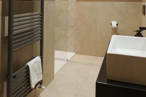 a bathroom with a sink and a toilet and a towel at Camillò Guest House in Ivrea