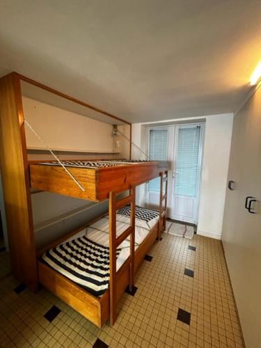 zwei Etagenbetten in einem Zimmer mit Fenster in der Unterkunft Les Avocettes in Quend-Plage