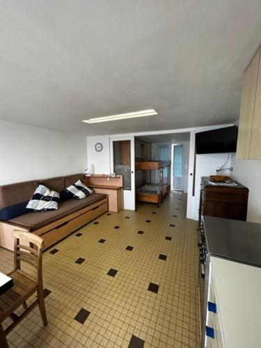 ein Wohnzimmer mit Sofa und eine Küche in der Unterkunft Les Avocettes in Quend-Plage
