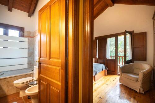 a bathroom with a bedroom with a bed and a toilet at Villa El Ñeru – Bufones de Pría, Llanes in Cuerres