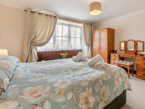 a bedroom with a large bed with a floral bedspread at 1 Bed in Helston oc-bbird in Saint Martin