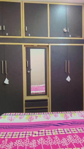 a bedroom with a bed and a window and cabinets at Sahib ka Ghar in Kharar