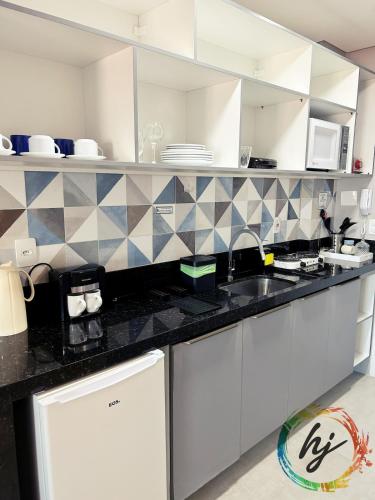 a kitchen with black and white tile on the wall at Vista Mare 402 in Ilha da Restinga