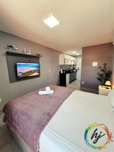 a bedroom with a bed with a tv on the wall at Vista Mare 402 in Ilha da Restinga