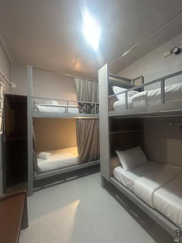 a room with three bunk beds in a room at Sleep Squad Hostel in El Nido