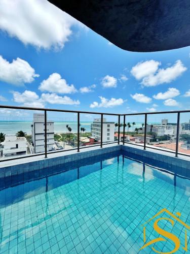 a swimming pool with a view of the ocean at Ble Camboinha 101 in Camalaú