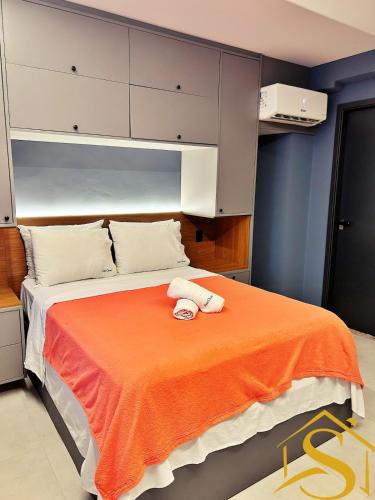 a bedroom with a bed with an orange blanket at Ble Camboinha 101 in Camalaú