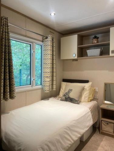 a bedroom with a bed with a dog sitting on it at Forest View at Oakdene Forest Park - Leisure Passes Included! in Ringwood