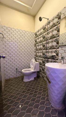 a bathroom with a toilet and a sink at Gulberg Inn Hotel Lahore in Lahore