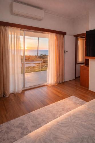 a bedroom with a large window with a view of the ocean at Upper Esplanade Oceanview Escape in Bunbury
