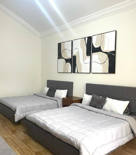 two beds in a white room with black and white at Evermond Suites in Alexandria