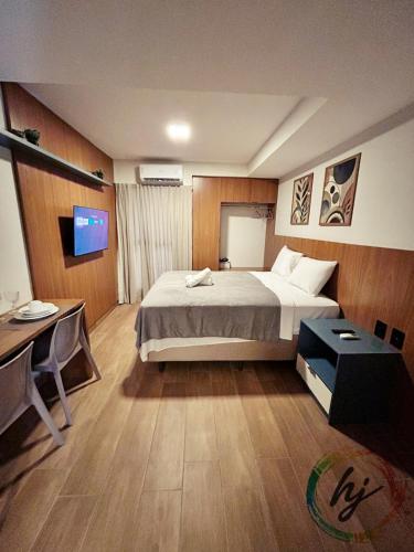a bedroom with a bed and a desk and a television at Mares Cabo Branco 209 in Tambaú