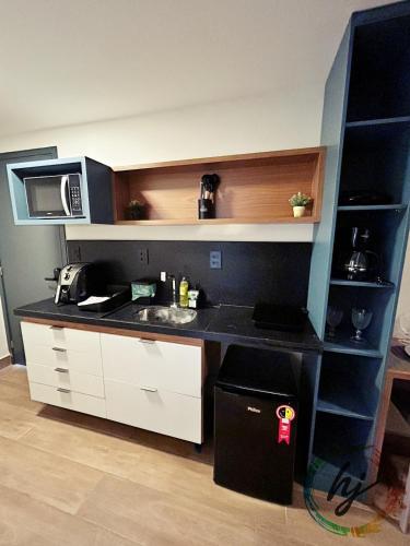 a small kitchen with a sink and a microwave at Mares Cabo Branco 209 in Tambaú