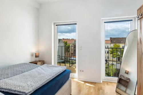 a bedroom with a bed and a balcony at Elbe Central Loft in Wittenberge