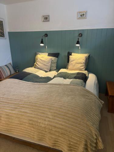 a bedroom with two beds and two lamps on the wall at Hyggelig lejlighed tæt på centrum in Silkeborg